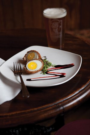 Bull’s Head Public House: Scotch egg, hardboiled, coated with sausage and breadcrumbs, deep-fried and served with a balsamic reduction and Sriracha